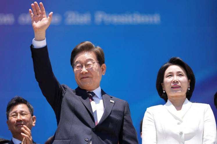 South Korea's President Lee Jae-myung (center) and his wife Kim Hye-kyung (right) leave after the inauguration ceremony at the National Assembly in Seoul on June 4, 2025. 