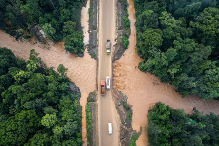 This aerial photo taken on April 14, 2025 shows a general view of a transport road of a nickel mining site, constructed after forests were cleared, next to a river residents say has been contaminated by mining operations in Central Halmahera, North Maluku. 
