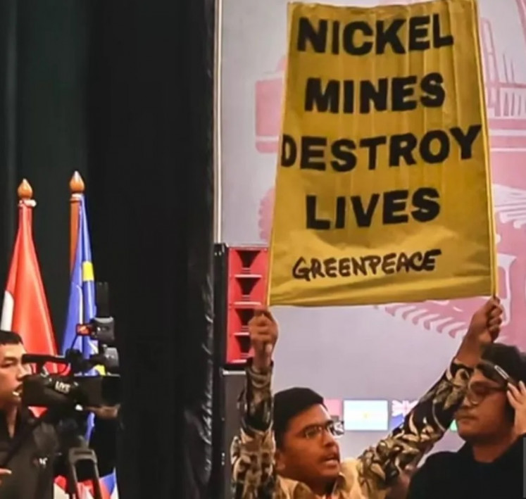 An activist from Greenpeace Indonesia displays a banner during a peaceful protest against nickel mining in Southwest Papua’s Raja Ampat on June 3, 2025, the first day of the Indonesia Minerals Conference & Expo that ran until June 5 at the Pullman Jakarta Central Park in Grogol, West Jakarta.