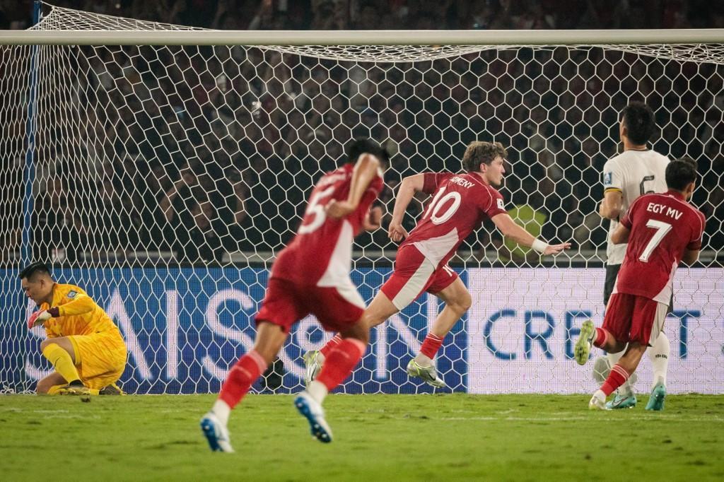 Indonesia's forward #10 Ole Romeny (center) celebrates after scoring the penalty kick against China's goalkeeper #14 Wang Dalei during the FIFA World Cup 2026 Asian qualifier football match between Indonesia and China at Gelora Bung Karno Stadium in Jakarta on June 5, 2025.