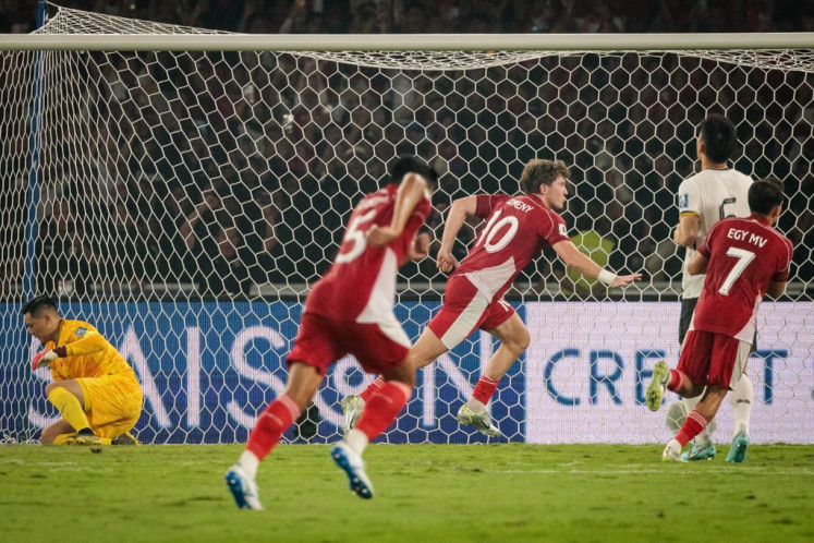 Indonesia's forward #10 Ole Lennard Romenij celebrates after scoring the penalty kick against China's goalkeeper #14 Wang Dalei during the FIFA World Cup 2026 Asian qualifier football match between Indonesia and China at Gelora Bung Karno Stadium in Jakarta on June 5, 2025.