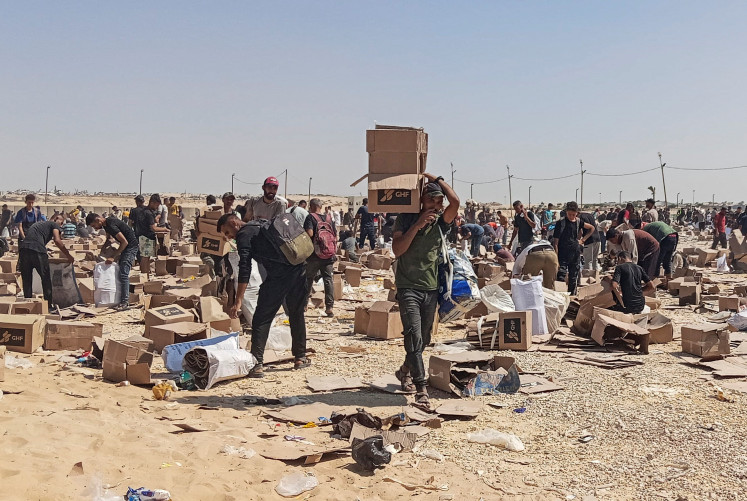 Palestinians gather to collect what remains of relief supplies from the distribution center of the US-backed Gaza Humanitarian Foundation, in Rafah, in the southern Gaza Strip, June 5, 2025. 