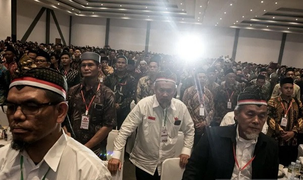 Show of loyalty: Former members of Jamaah Islamiyah (JI) sing the national anthem “Indonesia Raya” during an event on Dec. 21, 2024, held to declare the disbandment of the terrorist group at the Convention Hall of the Tirtonadi terminal in Surakarta, Central Java. 