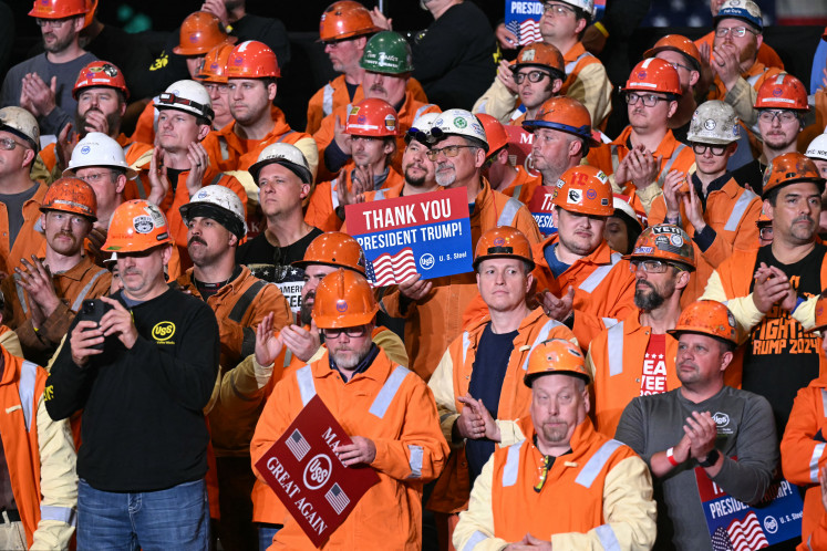 A steel worker holds a sign as United States President Donald Trump speaks during a visit to US Steel - Irvin Works in West Mifflin, Pennsylvania, the US, on May 30, to mark the deal between Nippon Steel and US Steel.