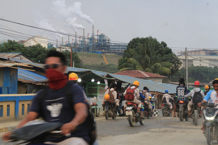 Mask up: Workers of the nickel plant operated by PT Indonesia Weda Bay Industrial Park (IWIP) ride on their motorcycles in the Central Weda district, Central Halmahera regency, North Maluku on Feb. 19, 2025. The industrial park is located around 100 meters from residential areas in the district.