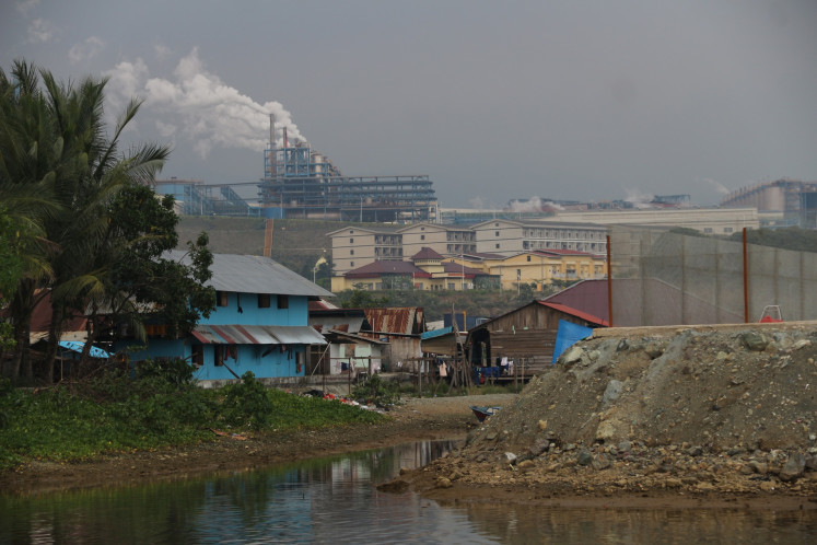 A white column of emissions rises from the nickel processing plant operated by PT Indonesia Weda Bay Industrial Park (IWIP) on Feb. 20, 2025, beyond the riverside village of Lelief in Central Weda district, Central Halmahera regency, North Maluku.