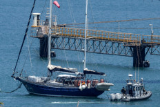 An Israeli police patrol boat moves near the aid sailboat Madleen as it is moored at the southern port of Ashdod on June 10, 2025 after being intercepted the previous day by Israeli forces. 