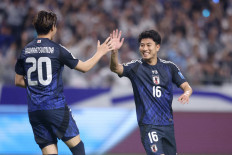 Japan's forward Mao Hosoya (right) is congratulated by teammate Kota Tawaratsumida (left) after scoring the team's sixth goal during the World Cup Asian qualifier Group C football match between Japan and Indonesia in Osaka on June 10, 2025. (Photo by/)