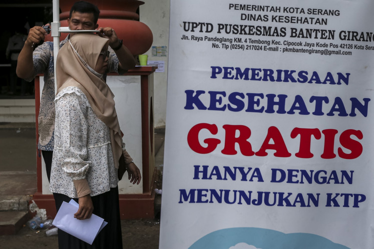 A health worker measures the height of a woman participating in the free birthday health screening program at a community health center (Puskesmas) in Serang, Banten, on May 15. Around 8.2 million people have undergone the free checkups across the country, according to data from the Health Ministry.