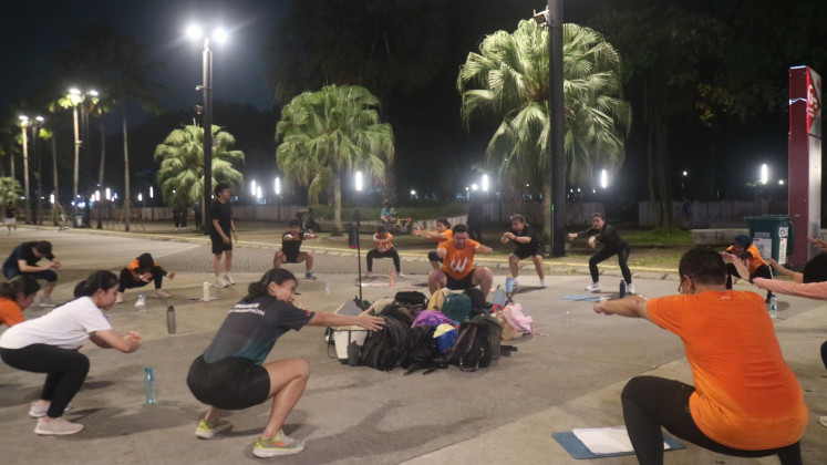 A group of individuals perform group exercise at the Gelora Bung Karno (GBK) sports complex in Central Jakarta on June 11, 2025. 