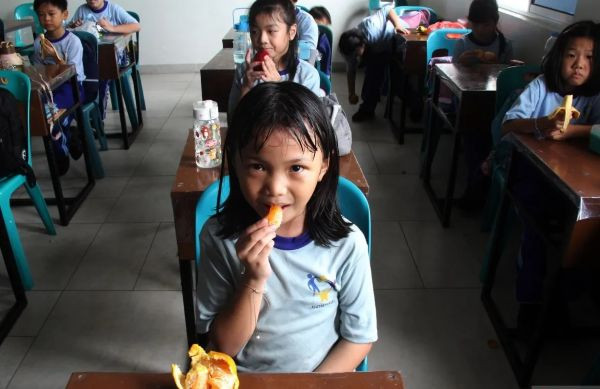 Save the best for last: Pupils of Maitreya Wira Dumai elementary school in Dumai, Riau, eat fruit after finishing their free nutritious meals on Jan. 7, 2025.