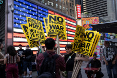 People hand out signs during a protest against Israeli strikes on Iran, in New York City, United States, June 13, 2025. 