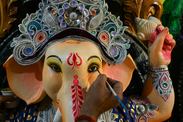 An artisan paints an eco-friendly idol of elephant-headed Hindu deity Ganesha made with mud, jute and bamboo to reduce water pollution during the immersion rituals ahead of the Ganesh Chaturthi festival, at a workshop in Hyderabad, India, on Aug. 28, 2024.