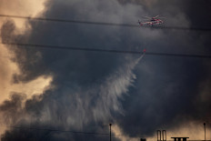 A fire-fighting helicopter battles a fire after a Russian missile and drone strike, amid Russia's attack on Ukraine, in Kyiv, Ukraine June 17, 2025. 
