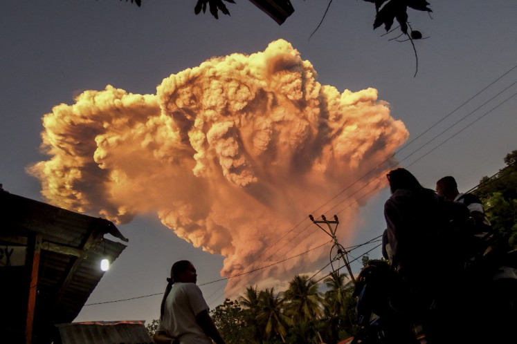 Villagers watch the eruption of Mount Lewotobi Laki-Laki as seen from Talibura village in Sikka, East Nusa Tenggara, on June 17, 2025. 