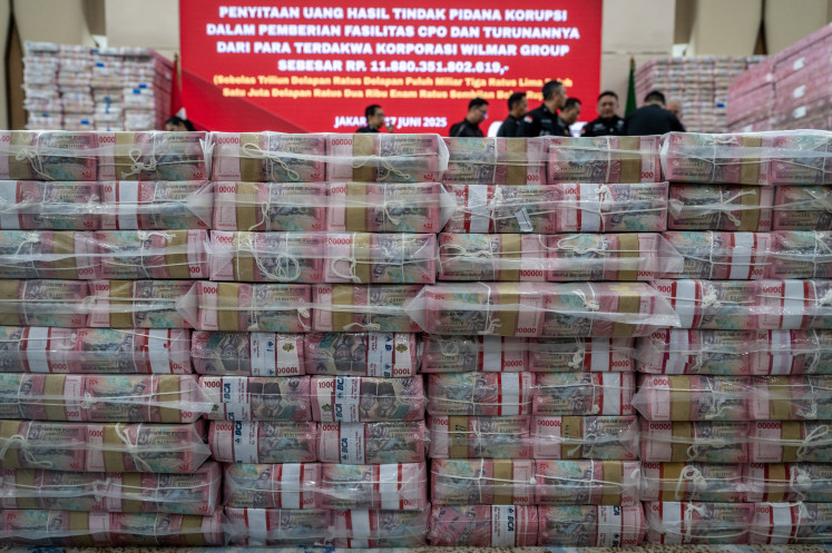 The Attorney General’s Office (AGO) displays stacks of money it confiscated from palm oil company Wilmar Group in relation to a court case about alleged corruption relating to palm oil export permits, during a press conference in Jakarta on June 17.