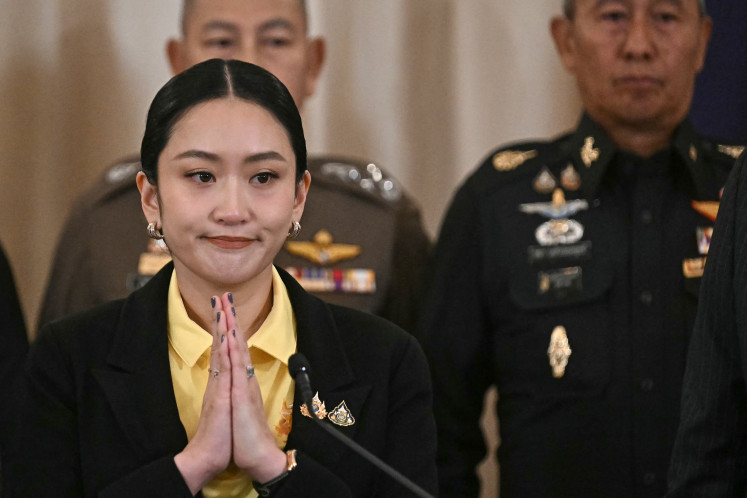 Thailand's Prime Minister Paetongtarn Shinawatra (left) gestures at a press conference next to Armed Forces Commander Pana Klaewplodthuk at Government House in Bangkok on June 19, 2025. Paetongtarn on June 19 apologized for her leaked phone call with Cambodia's ex-leader, which prompted a political crisis that threatened to collapse her government.
