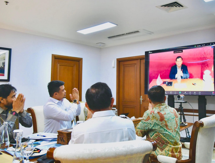 President Prabowo Subianto (on screen) greets Aceh Governor Muzakir Manaf (left), North Sumatra Governor Bobby Nasution (second left), Home Minister Tito Karnavian (second right) and State Secretary Prestyo Hadi (right) when leading a meeting on a border dispute over four contested islands between Aceh and North Sumatra in the State Secretariat's office in Jakarta on June 17, 2025.