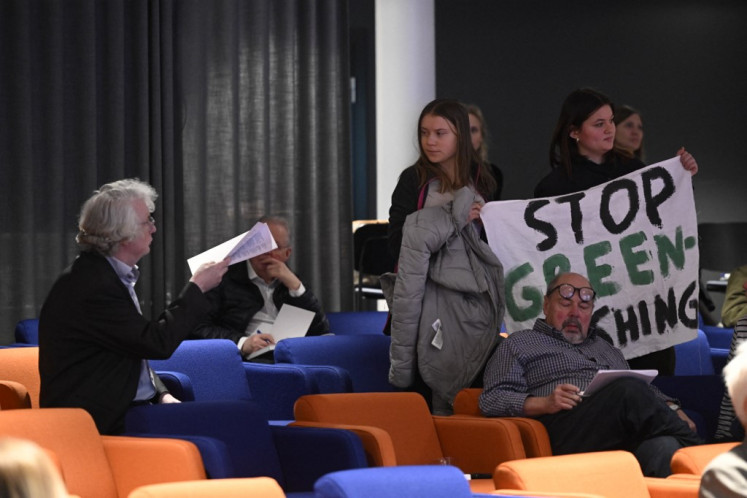 Swedish climate activist Greta Thunberg and activists from the Fridays For Future movement protest with a banner reading “SAS stop greenwashing“ during the Scandinavian Airlines SAS' general meeting at the company's headquarters in Froesundavik near Stockholm on March 18, 2024.