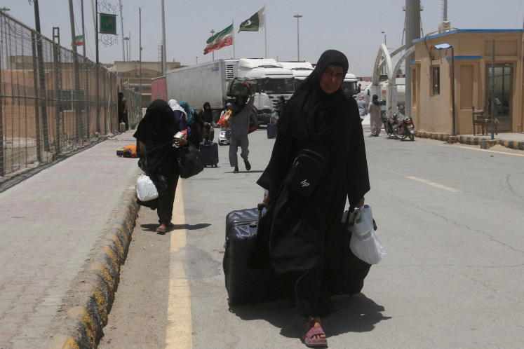 Return home: Pakistani pilgrims walk with their belongings on June 19 after their return from Iran following the Israeli strikes in Iran at the Pakistan-Iran border crossing in Taftan, Pakistan.