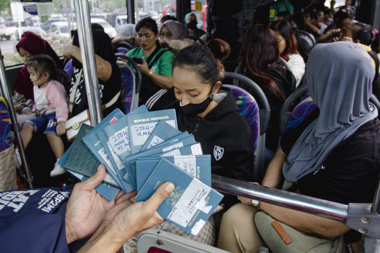 Homecoming: An official with the Migrant Workers Protection Agency (BP3MI) shows several passports owned by Indonesian migrant workers who just arrived at the Batam Center International Seaport in Riau Islands on May 22. The Riau Islands BP3MI received at least 72 Indonesian migrant workers repatriated through the province from Malaysia.