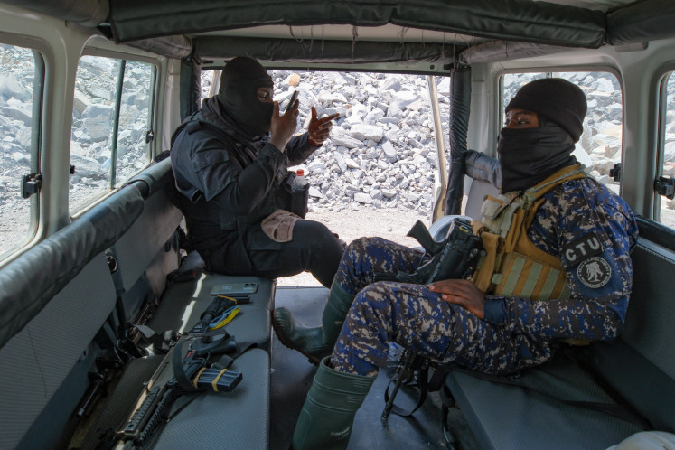 Masked security personnel prepare for an anti-illegal mining operation at the Gold Fields Mine in Tarkwa, Ghana, on April 10, 2025.