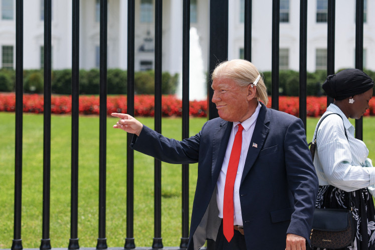 A person dressed as United States President Donald Trump greets visitors on June 22, 2025, outside the White House in Washington, DC.