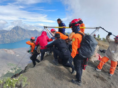 Ongoing effort: A search and rescue (SAR) worker (left) prepares to descend into Mt. Rinjani crater on Monday to find a fallen Brazilian climber in East Lombok regency, West Nusa Tenggara. The female climber fell on Saturday morning.