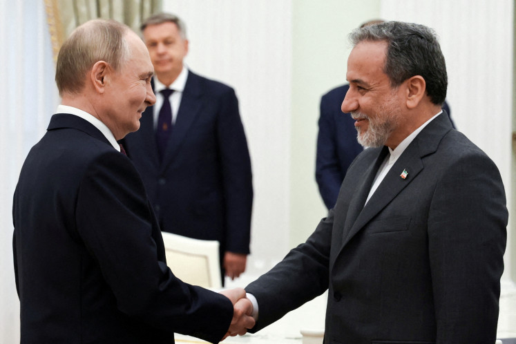 Russian President Vladimir Putin (left) shakes hands with Iranian Foreign Minister Abbas Araqchi during a meeting at the Kremlin in Moscow, Russia June 23, 2025.