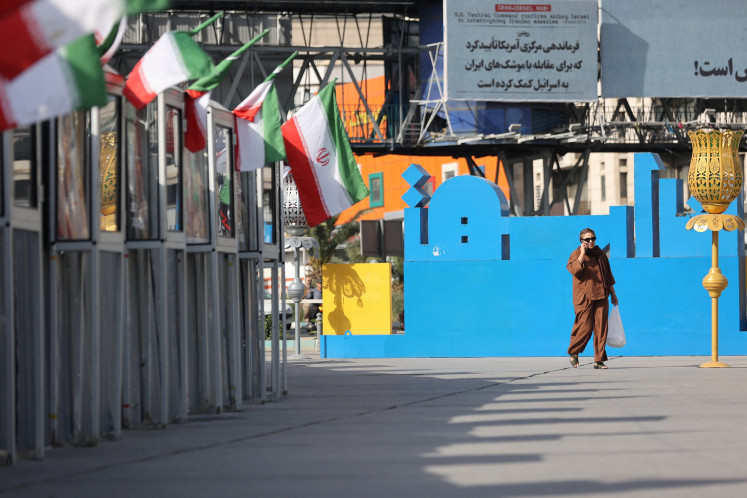 A woman walks on a street, amid the Iran-Israel conflict, in Tehran, on June 23, 2025.