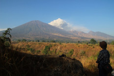 This picture taken in Sembalun, East Lombok, Nusa Tenggara Barat on November 10, 2015 shows a man looking at mount Barujari (child of Rinjani).