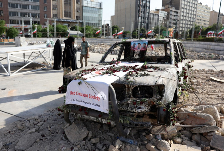 Iranians check an Iranian Red Crescent ambulance that was destroyed during an Israeli strike, displayed in Tehran on June 23,2025. I