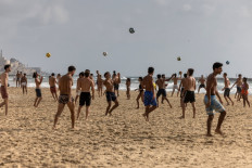 People play on the beach in Tel Aviv as the Iran-Israel war ground into its 11th day on June 23, 2025. 