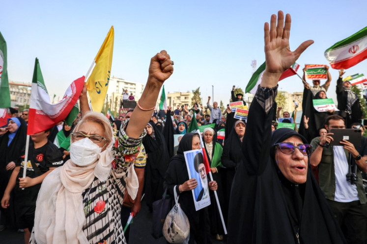Iranians chant slogans and wave national flags as they celebrate a ceasefire between Iran and Israel at Enghlab Square in the capital Tehran on June 24, 2025. A fragile ceasefire in the Iran-Israel war appeared to be holding on June 24, after 12 days of strikes that saw Israel and the United States pummel the Islamic republic's nuclear facilities.