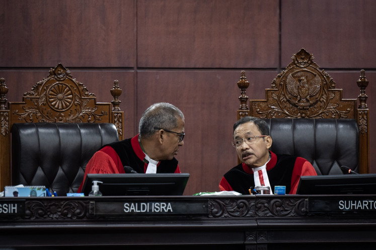 Constitutional Court Chief Justice Suhartoyo (right) talks with Deputy Chief Justice Saldi Isra (left) during a hearing of judicial review petition against the Indonesian Military (TNI) Law at the Constitutional Court in Jakarta on June 23, 2025. Saldi ask the representatives from the government and House of Representatives on why the revision to the law extended beyond the court's order of revising military officers' retirement age.