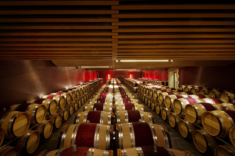 Hundreds of oak barrels line the modern cellar at the centuries-old Ch'teau Angélus in Saint-Émilion, France.