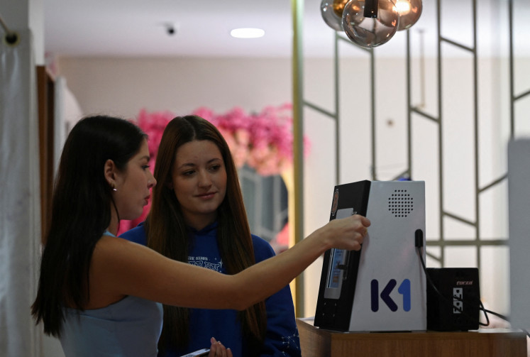 Women try a cryptocurrency kiosk at a spa, as some Bolivians turn to platforms like Binance, cryptocurrencies like Bitcoin, and stablecoins like Tether as a hedge against depreciation of the boliviano, in Cochabamba, Bolivia, on June 12, 2025. 