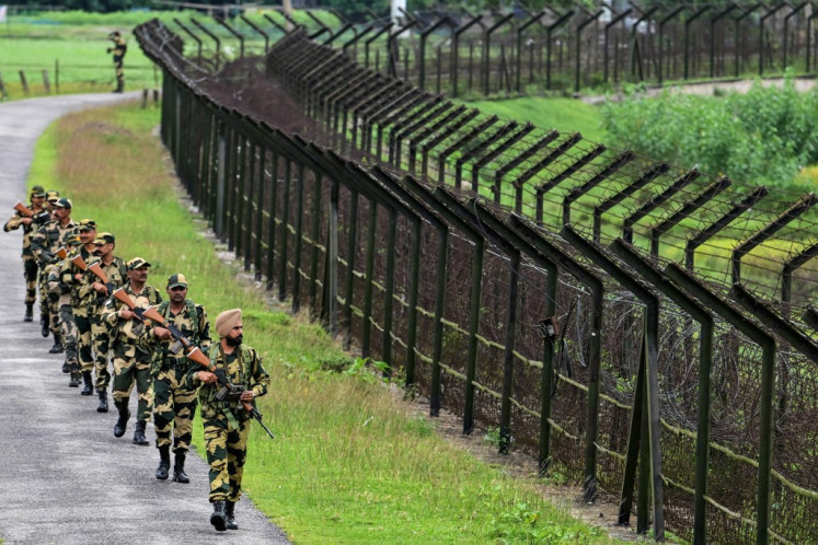 Border Security Force (BSF) personnel patrol along the borderline fence at the India-Bangladesh border in Golakganj, Dhubri district in India's Assam State on May 26, 2025. 