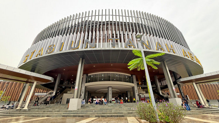 People lounge atop the stairs leading the new building at Tanah Abang Station in Central Jakarta on June 29, 2025, the day it opened.