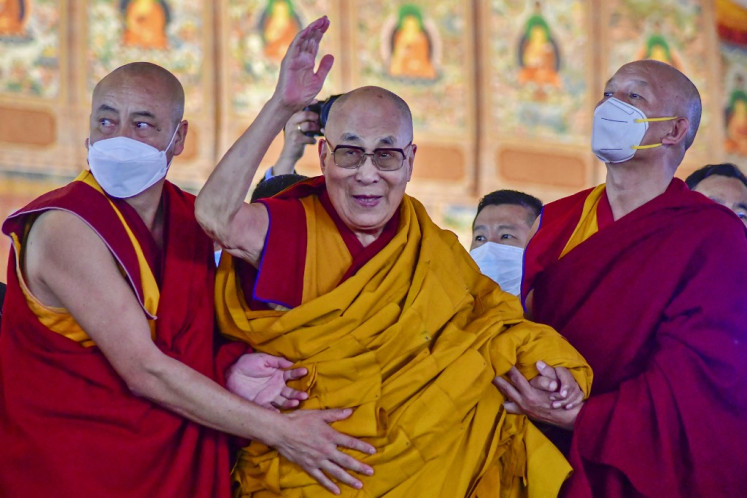 Tibetan spiritual leader the Dalai Lama (center) waves during the first day of his teaching session at the Kalachakra Ground in Bodhgaya on December 29, 2022. The Dalai Lama, the charismatic Buddhist spiritual leader lauded worldwide for his tireless campaign for greater autonomy for his Tibetan homeland, will celebrate his 90th birthday in July. 