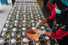 A worker prepares meal packages for the free nutritious meal program on Feb. 12 in the kitchen of an Islamic boarding school in Kudus regency, Central Java. 