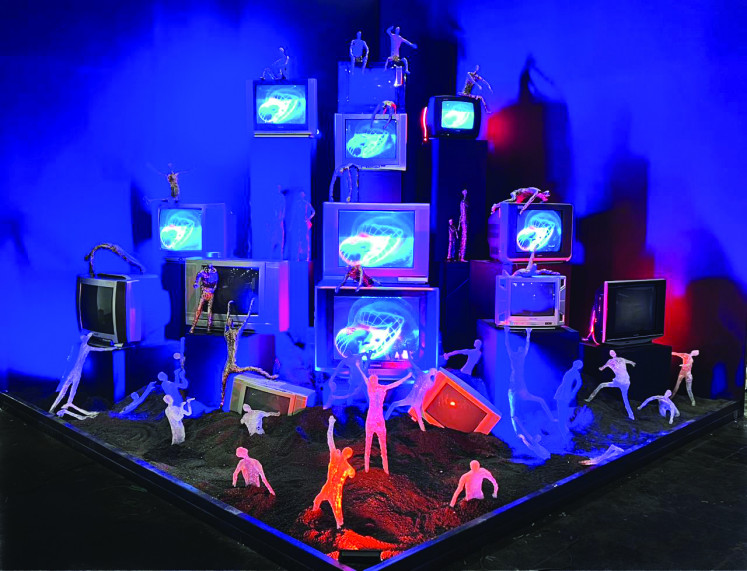'Simulacra Echoes' by Ade Artie consisting of TV sets and resin sculptures moving on a sand platform in a simulation of cognitive confusion.