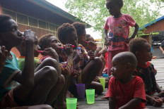 Dental lesson: The children of Agats, the capital of South Papua’s Asmat regency sit on a wooden deck at the local church, practicing dental hygiene with new toothbrushes and rinsing cups under local health workers’ guidance.