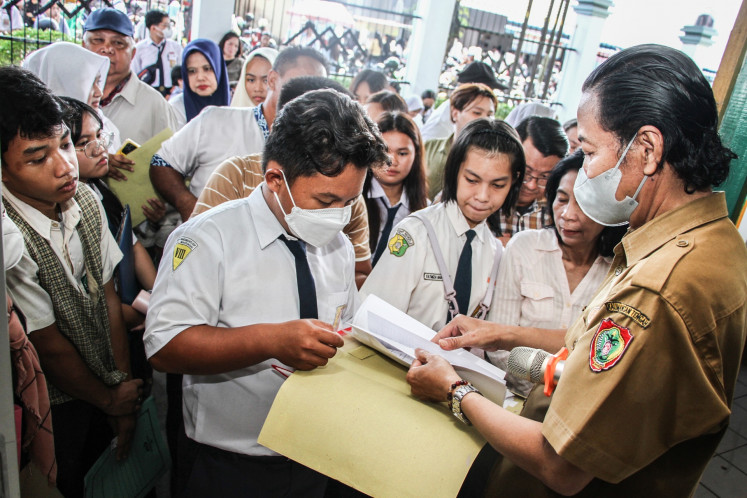 In-person assistance: A teacher checks on a student's application document at the SMK 3 Palangka Raya state vocational school on June 23 in Palangka Raya, Central Kalimantan. The Central Kalimantan Education Agency opened the online registration for school admissions from June 23 to 26.