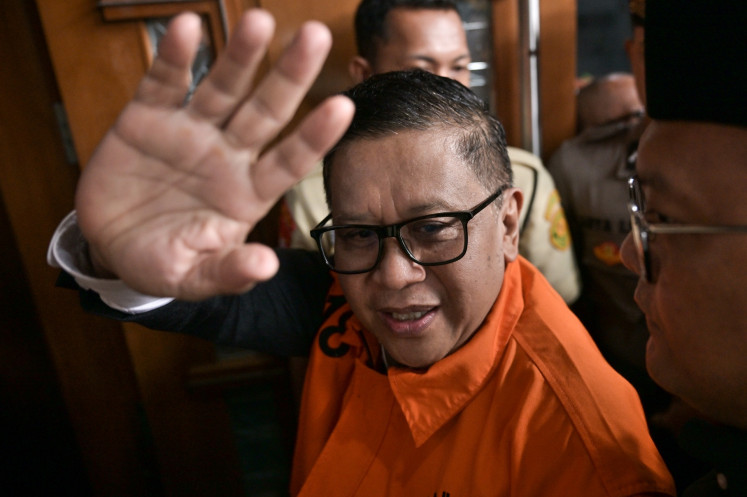 Indonesian Democratic Party of Struggle (PDI-P) secretary-general and graft defendant Hasto Kristiyanto waves to journalists upon walking to the courtroom of the Jakarta Corruption Court in Jakarta on July 3. Corruption Eradication Commission (KPK) prosecutors demand the judge punish Hasto with a seven-year imprisonment and a Rp 600 million (US$36,947) fine in a bribery and obstruction of justice case involving a former General Elections Commission (KPU) member.