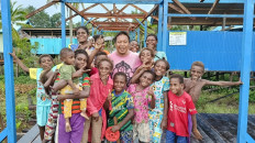 Happy learning: Elementary school teacher Longinus Hadi poses with his students in Per village in Agats district, South Papua’s Asmat regency, in October 2023.