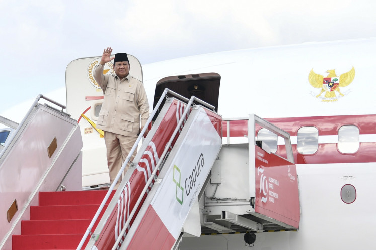 President Prabowo Subianto waves before entering the presidential plane at the Halim Perdanakusuma Air Force Base in East Jakarta on July 1, 2025, ahead of his state visit to Saudi Arabia and Brazil.