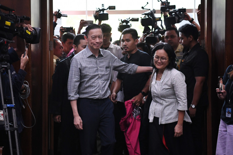 Former trade minister and graft defendant Thomas Lembong (left) embraces his wife Maria Franciska Wihardja (right) upon entering the Jakarta Corruption Court courtroom on Friday in Jakarta ahead of a hearing. Prosecutors demanded that the judges sentence Thomas to seven years behind bars for his alleged role in a corruption case pertaining to raw sugar imports.