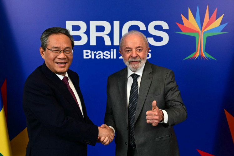 Brazil's President Luiz Inacio Lula da Silva (right) gives his thumb up while shaking hands with China's Premier Li Qiang, during a bilateral meeting ahead of the BRICS summit in Rio de Janeiro, Brazil, on July 5, 2025. 