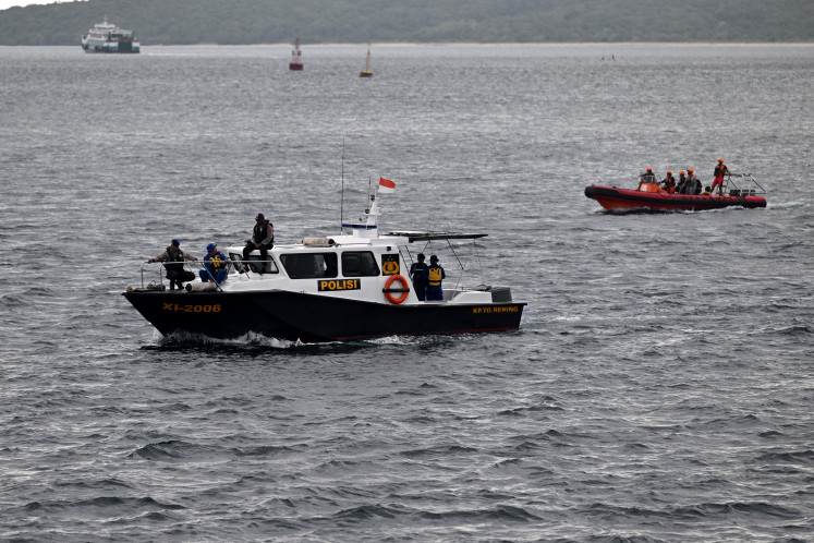 Rescuers (right) and marine police officers search for missing victims of a ferry accident in the waters off the Bali Strait near Jembrana, on Bali island on July 5. Hundreds of Indonesian rescuers widened their search for dozens of missing people on July 4, after a ferry sank in rough seas on the way to Bali.